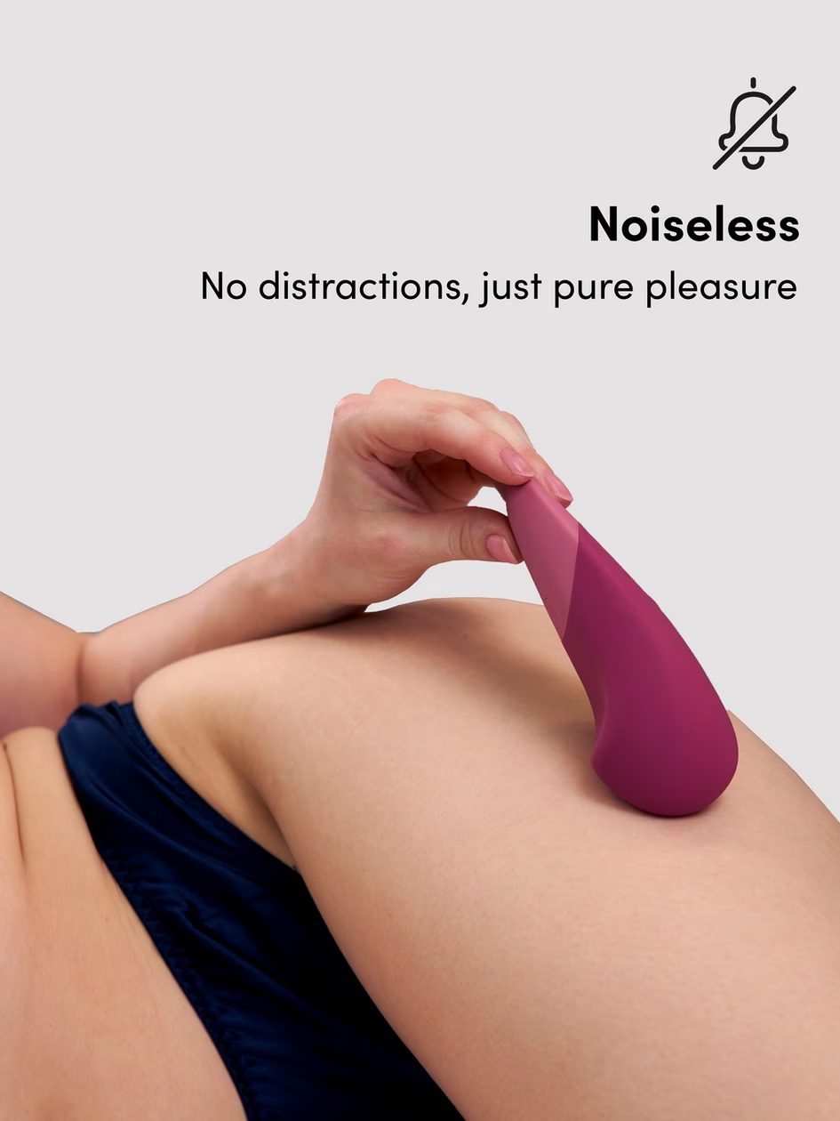 Pink vibrator being held against thigh skin.