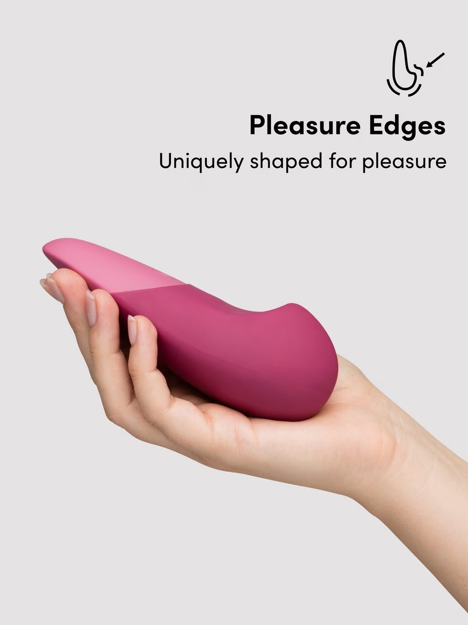 Pink vibrator being held in a palm, showing pleasure edges.